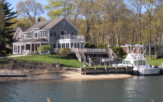 A house connected to a pier with a yacht