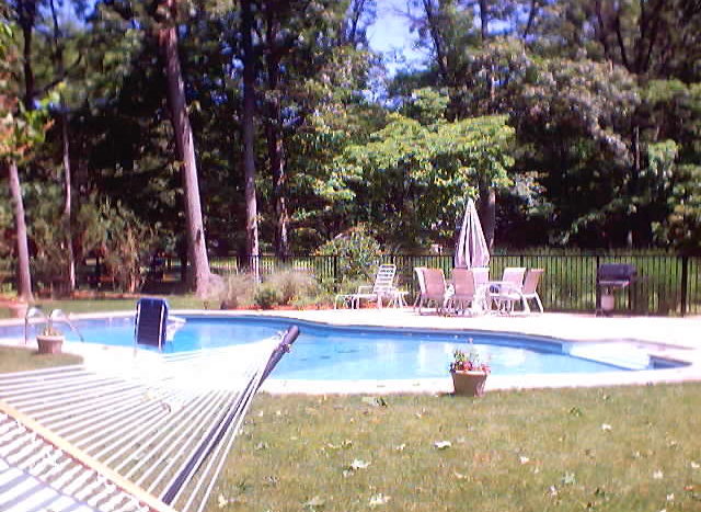 A swimming pool area with outdoor furniture