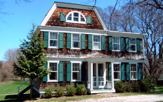 A brick house with green window shutters