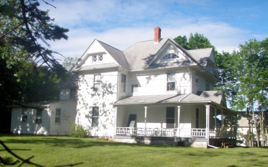 A white and gray house with a red chimney